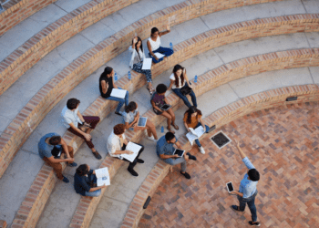 Group of college students engaged in a leadership lecture, actively participating and developing their skills in an open outdoor setting