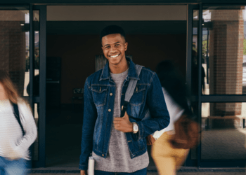 Happy college student at entrance, representing success in changing majors and excelling in college