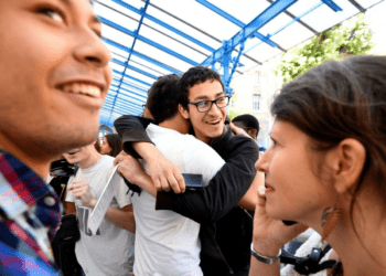 Group of smiling college students celebrating friendship and success, emphasizing the top skills needed to supercharge your freshman year.