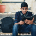 A focused Indian college student gaining knowledge and inspiration from his iPad, following the success tips for CS undergrads in their first year.