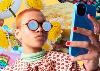 Brown female influencer in colorful attire, holding phone, exuding confidence in influencer marketing.