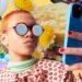 Brown female influencer in colorful attire, holding phone, exuding confidence in influencer marketing.