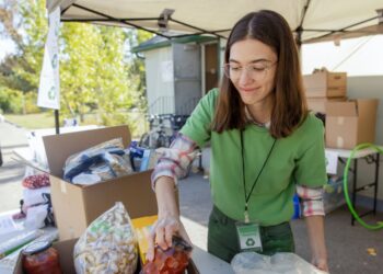 Community Recycling Volunteer packing food in brown box - Exploring career opportunities through volunteering.