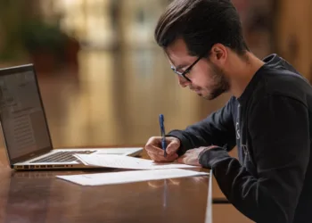 Dedicated male CS student taking notes while seated, preparing for career-enhancing exams during 4th year B.Tech CSE.
